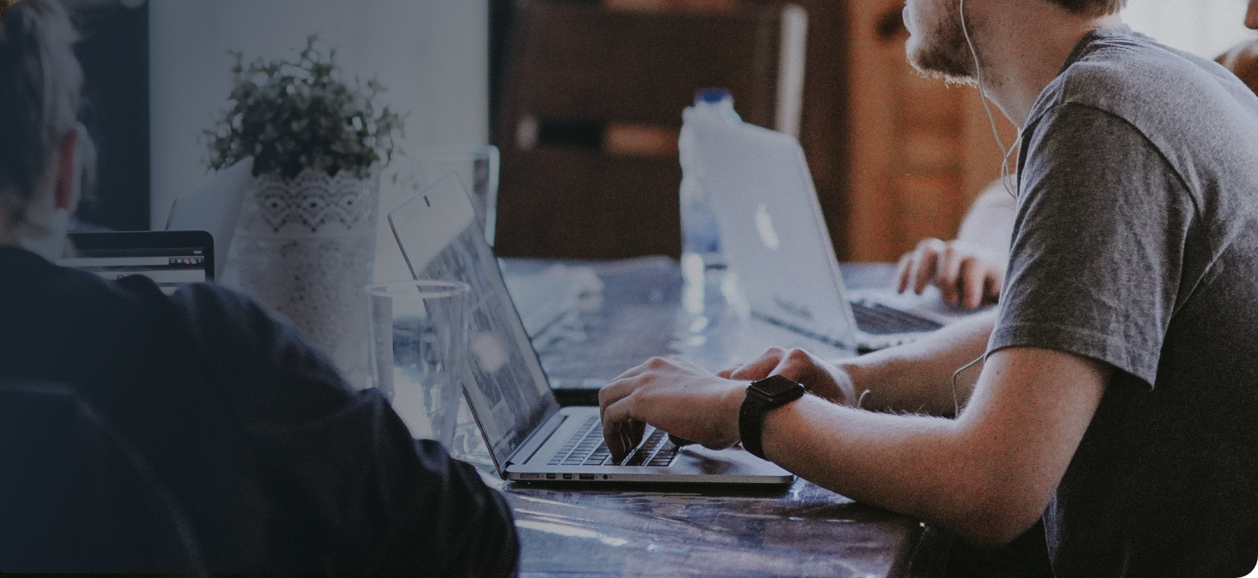 Two individuals focused on their laptops, working diligently at a table.