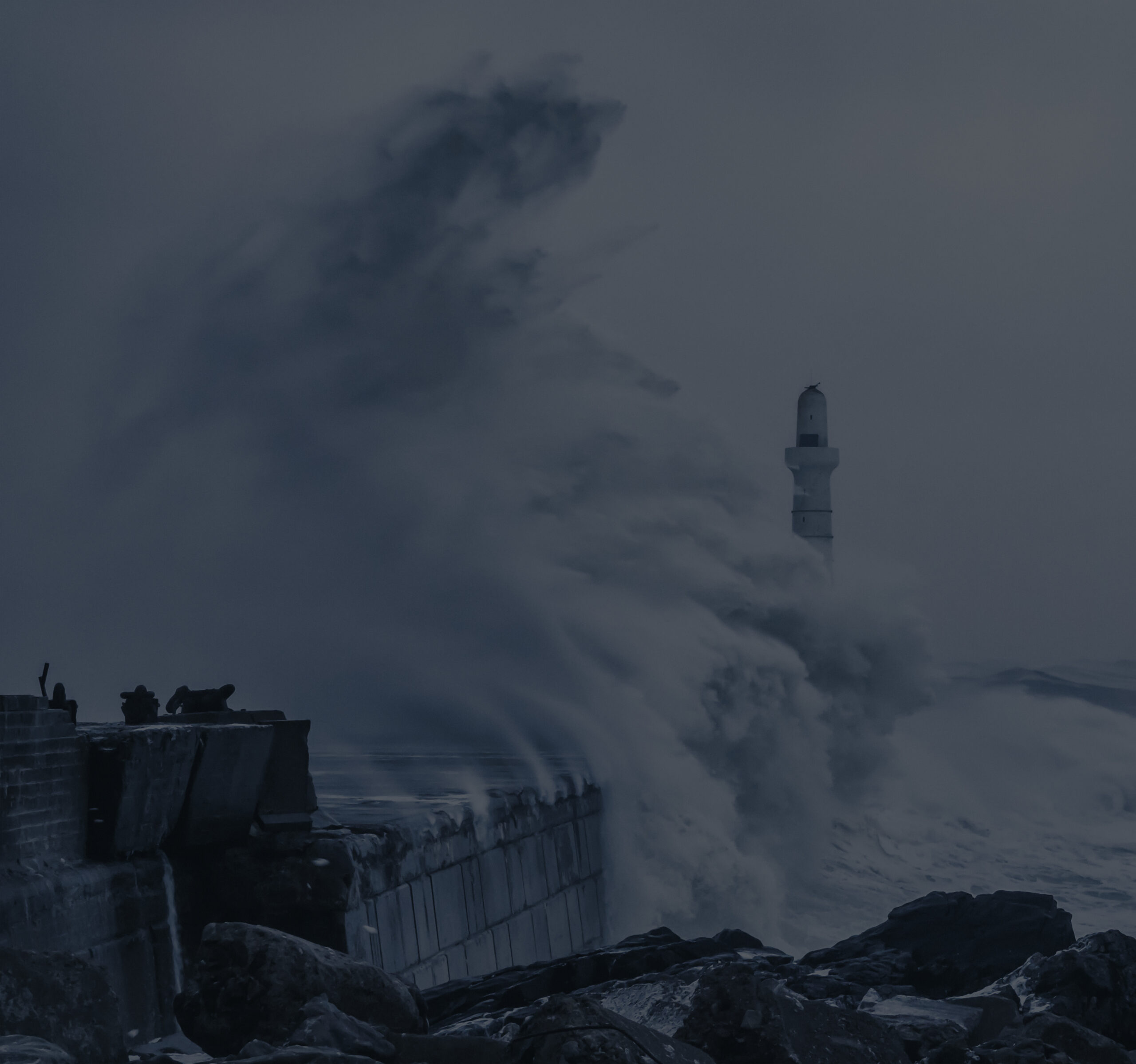 a dark seascape with waves hitting a lighthouse