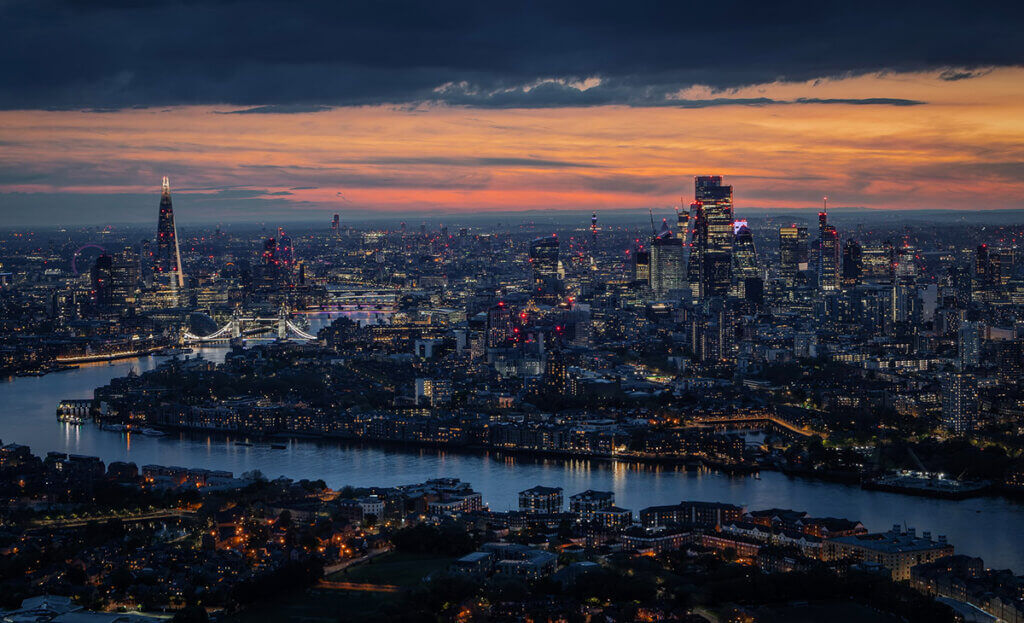 Wide aerial panorama of the illuminated London skyline during evening