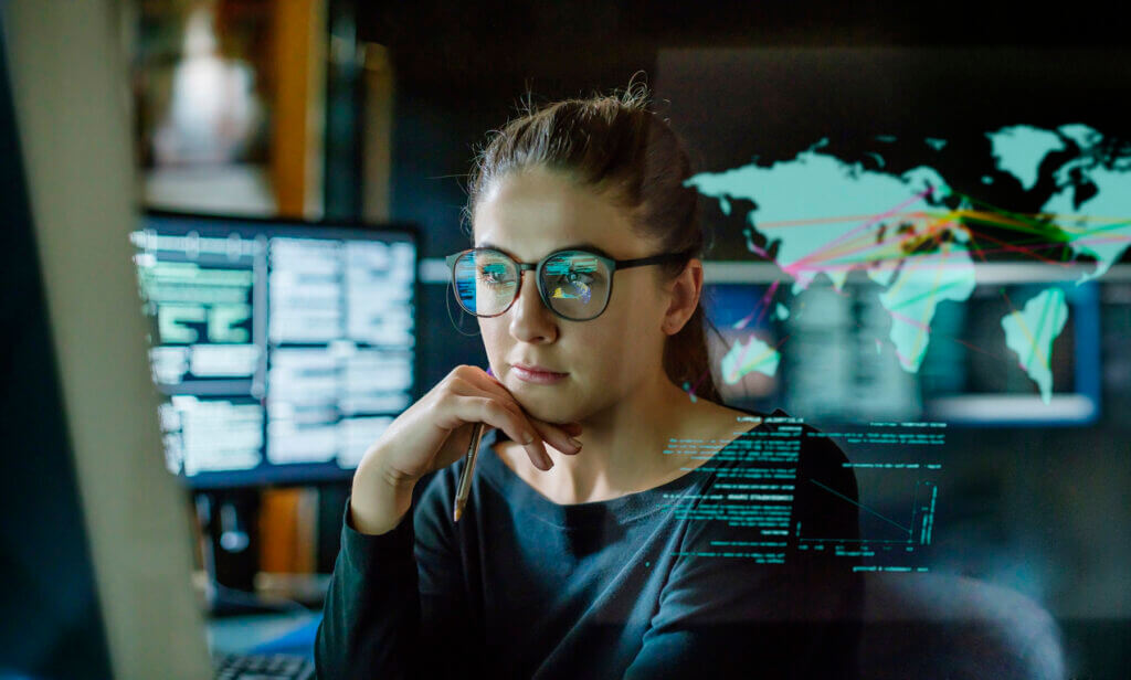An employee with glasses on looking at a network.